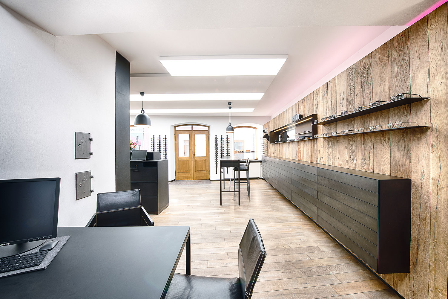 Ladeneinrichtung aus Holz und Stahl mit Brillenpräsentation